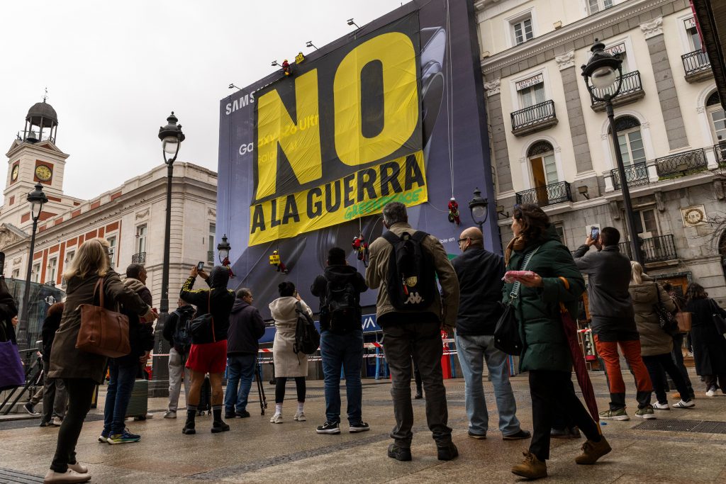 Greenpeace descuelga una pancarta gigante en la Puerta del Sol de Madrid con el NO A LA GUERRA