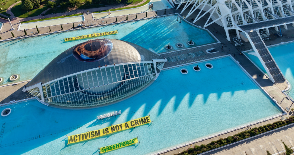 Greenpeace despliega un enorme ojo en el Hemisfèric de Valencia con el mensaje “El mundo está observando” en defensa de los activistas acusados en el caso Sagunto